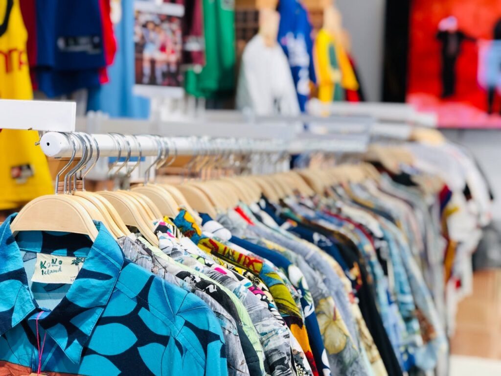 A vibrant collection of Hawaiian shirts on hangers in a clothing store with varied designs and colors.